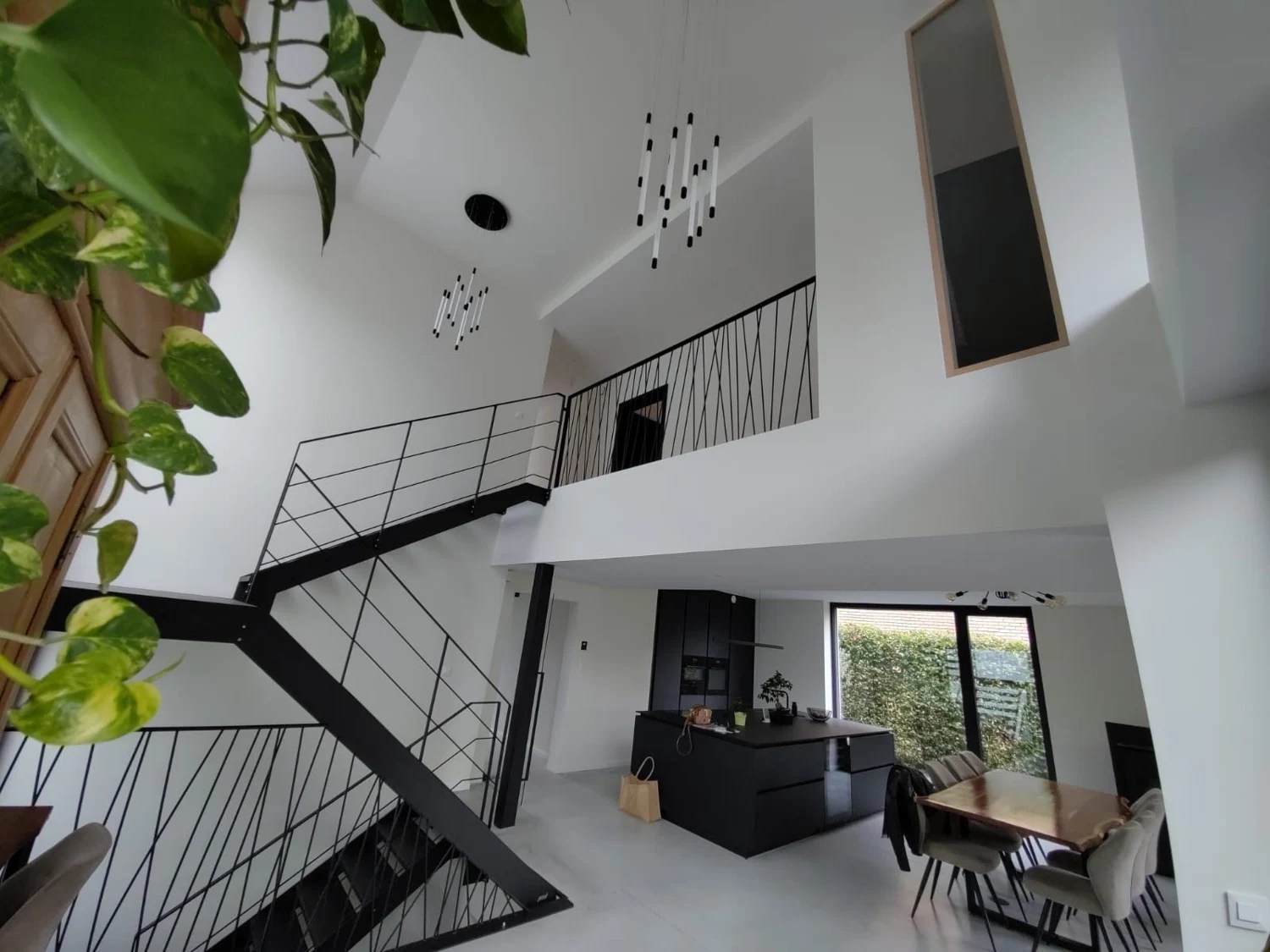 Escalier à deux volées et garde-corps noirs dans un intérieur aménagé