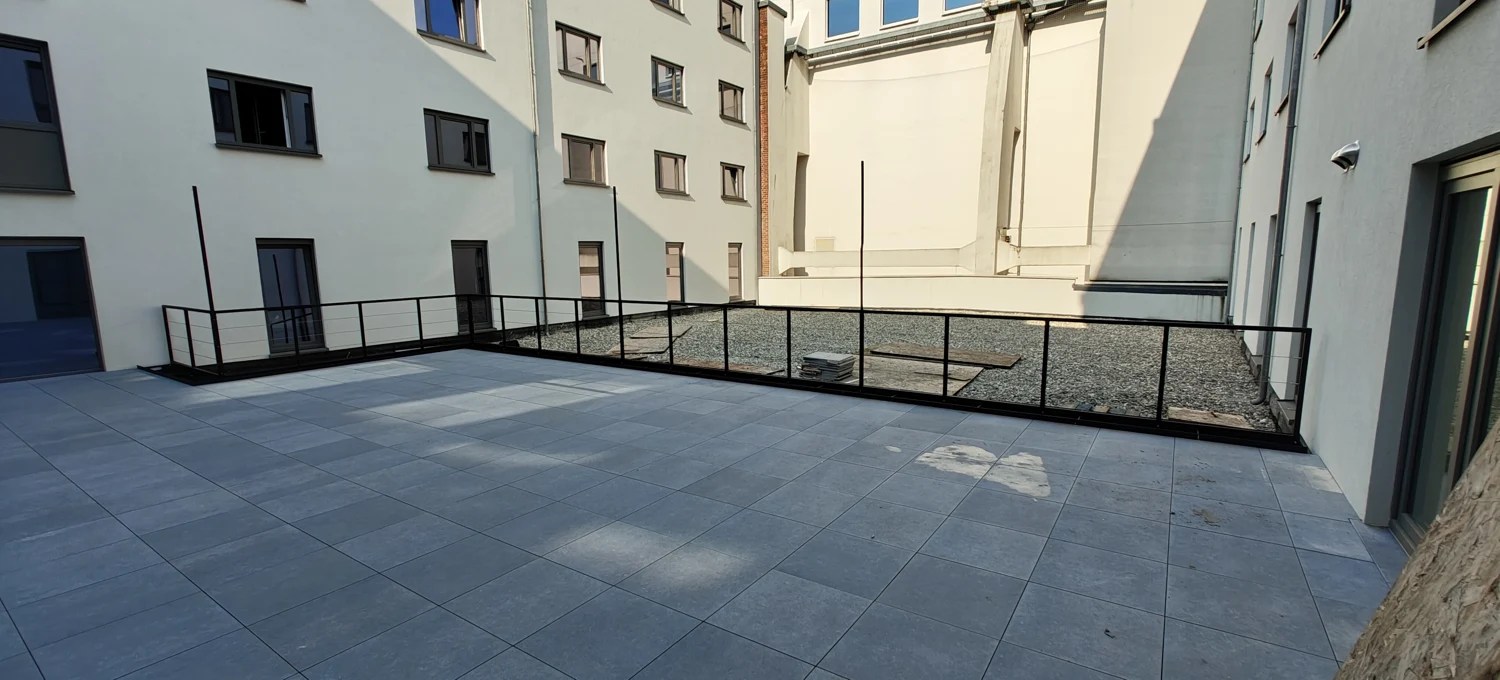 Garde-corps noir à lisses horizontales autour d’une terrasse extérieure