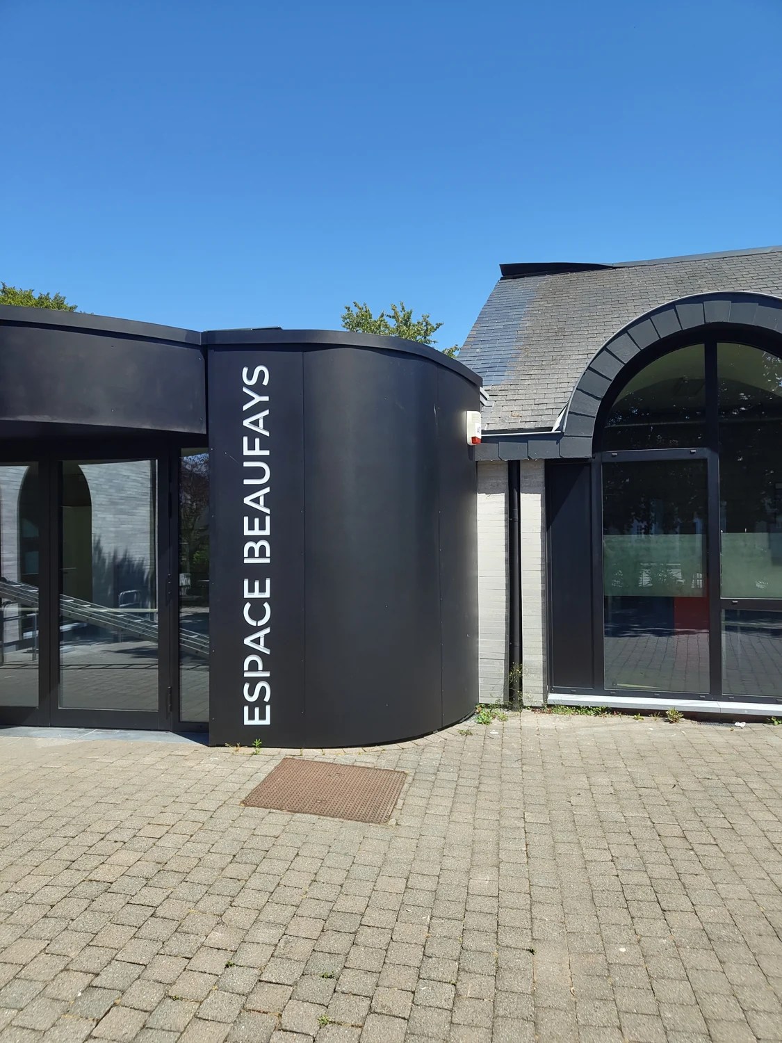 Détail de l’arrondi de l’habillage métallique et du lettrage Espace Beaufays