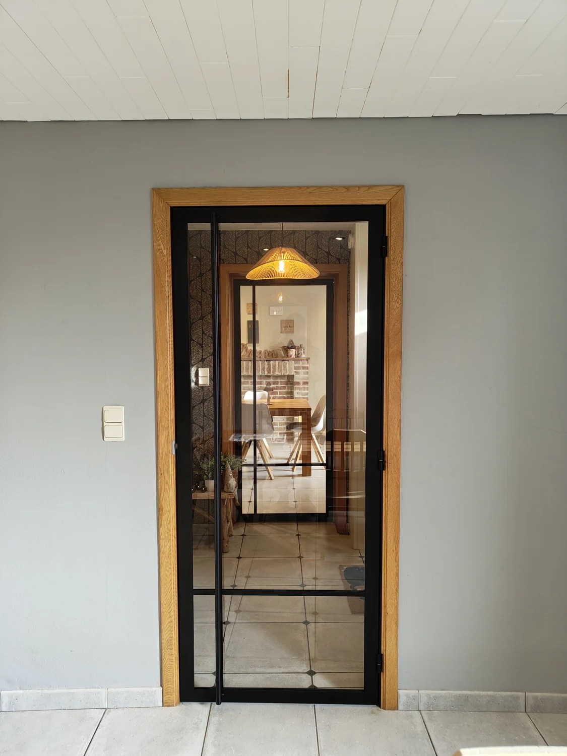 Vue de face de la porte vitrée et de son cadre noir